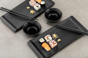 Productfoto sushi dinerset zwart eetstokjes bowls bordjes restaurant horeca keuken sfeer food